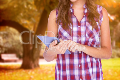 Composite image of pretty brunette using tablet computer