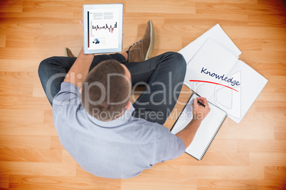Knowledge against young creative businessman looking at tablet