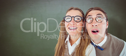 Composite image of geeky hipster couple raising eyes