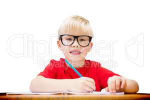 Composite image of cute pupil at desk