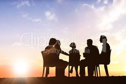 Composite image of silhouettes sitting