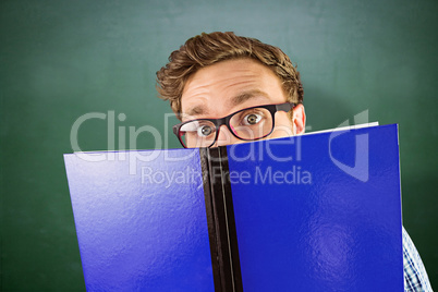 Composite image of geeky student reading a book