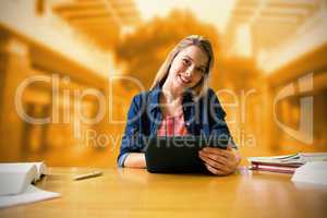 Composite image of student studying in the library with tablet