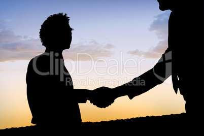 Composite image of silhouettes shaking hands