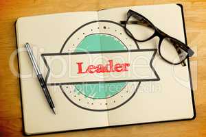 Leader against overhead of open notebook with pen and glasses