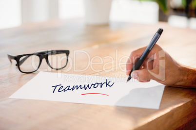 Teamwork against side view of hand writing on white page on work