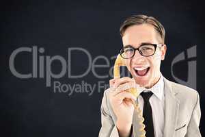 Composite image of geeky businessman talking on retro phone