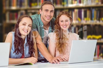 Composite image of fashion students using laptop Composite image of fashion students using laptop