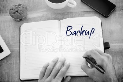 Backup against man writing notes on diary