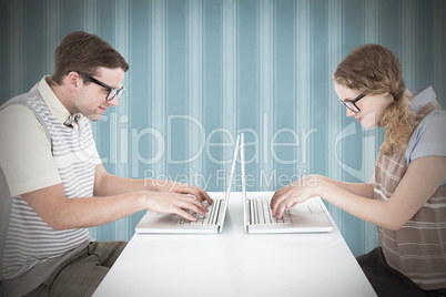 Composite image of geeky hipster couple using laptop