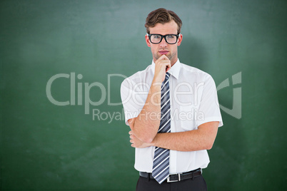 Composite image of serious geeky businessman thinking and holdin