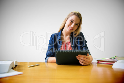 Composite image of student studying in the library with tablet