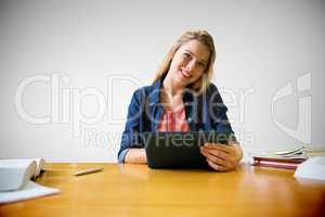 Composite image of student studying in the library with tablet