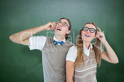 Composite image of geeky hipsters looking confused