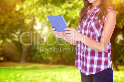 Composite image of happy pretty brunette using tablet computer