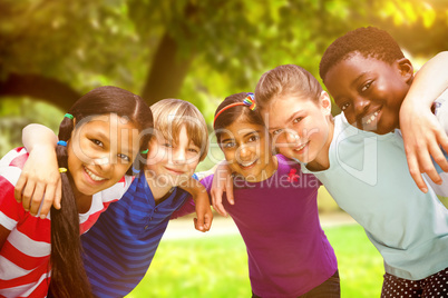 Composite image of happy children forming huddle at park