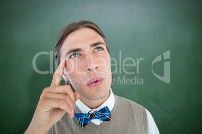 Composite image of geeky hipster thinking with hand on temple