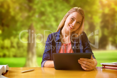 Composite image of student studying in the library with tablet