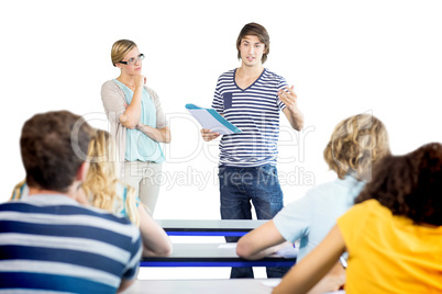 Student explaining notes besides teacher in class Student explaining notes besides teacher in class