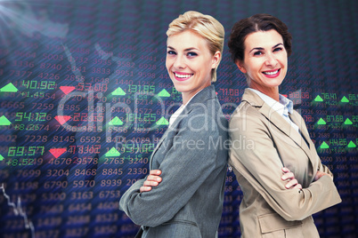 Composite image of serious businesswomen standing back on back