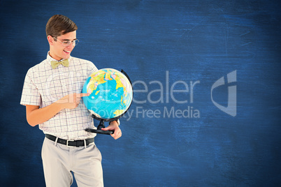 Composite image of geeky hipster holding a globe smiling at came