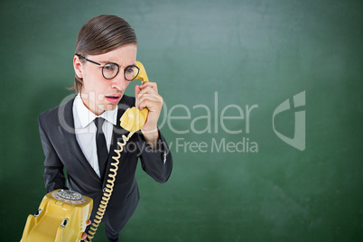 Composite image of focused geeky businessman on the phone