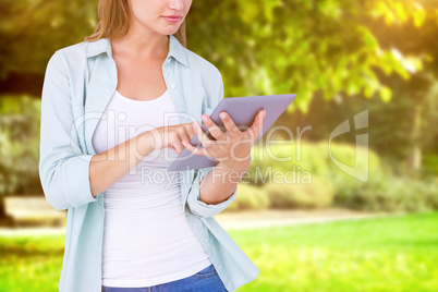 Composite image of pretty hipster using tablet