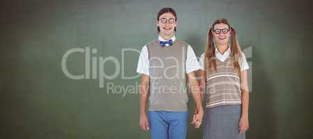 Composite image of geeky hipster couple holding hands