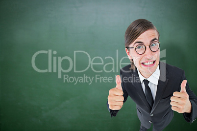 Composite image of geeky businessman looking at camera thumbs up