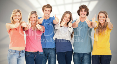 Composite image of six friends giving thumbs up as they smile