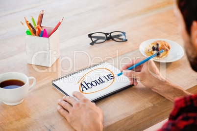 About us against creative businessman writing notes on notebook