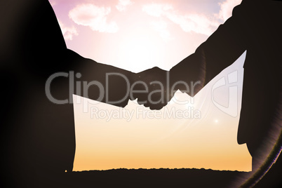 Composite image of silhouettes shaking hands