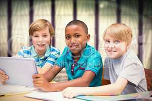 Composite image of cute pupils using tablet computer in library