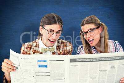 Composite image of geeky hipsters reading the newspaper