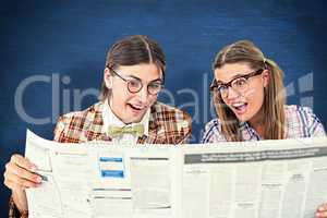 Composite image of geeky hipsters reading the newspaper