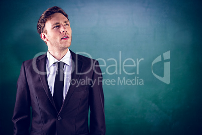 Composite image of young businessman thinking and looking up