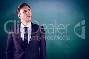 Composite image of young businessman thinking and looking up