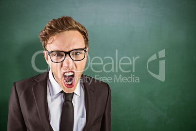 Composite image of young angry businessman shouting at camera