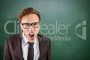 Composite image of young angry businessman shouting at camera