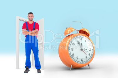 Composite image of handyman in overalls standing arms crossed ov