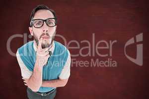 Composite image of geeky hipster looking confused at camera