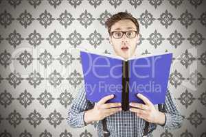 Composite image of geeky businessman holding a book