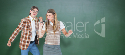 Composite image of happy geeky hipsters singing with microphone