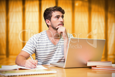 Composite image of student studying in the library with laptop