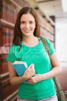 Composite image of student smiling at camera in library