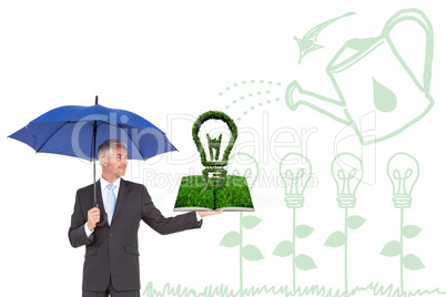 Composite image of man holding umbrella and lawn book