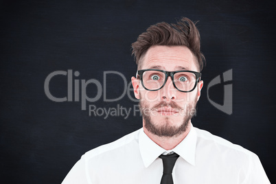 Composite image of geeky young businessman looking at camera