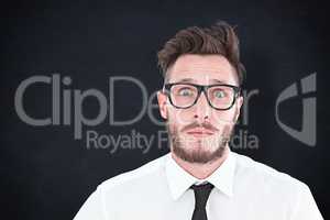 Composite image of geeky young businessman looking at camera