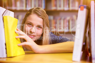 Composite image of pretty student in the library