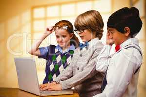 Composite image of pupils using laptop